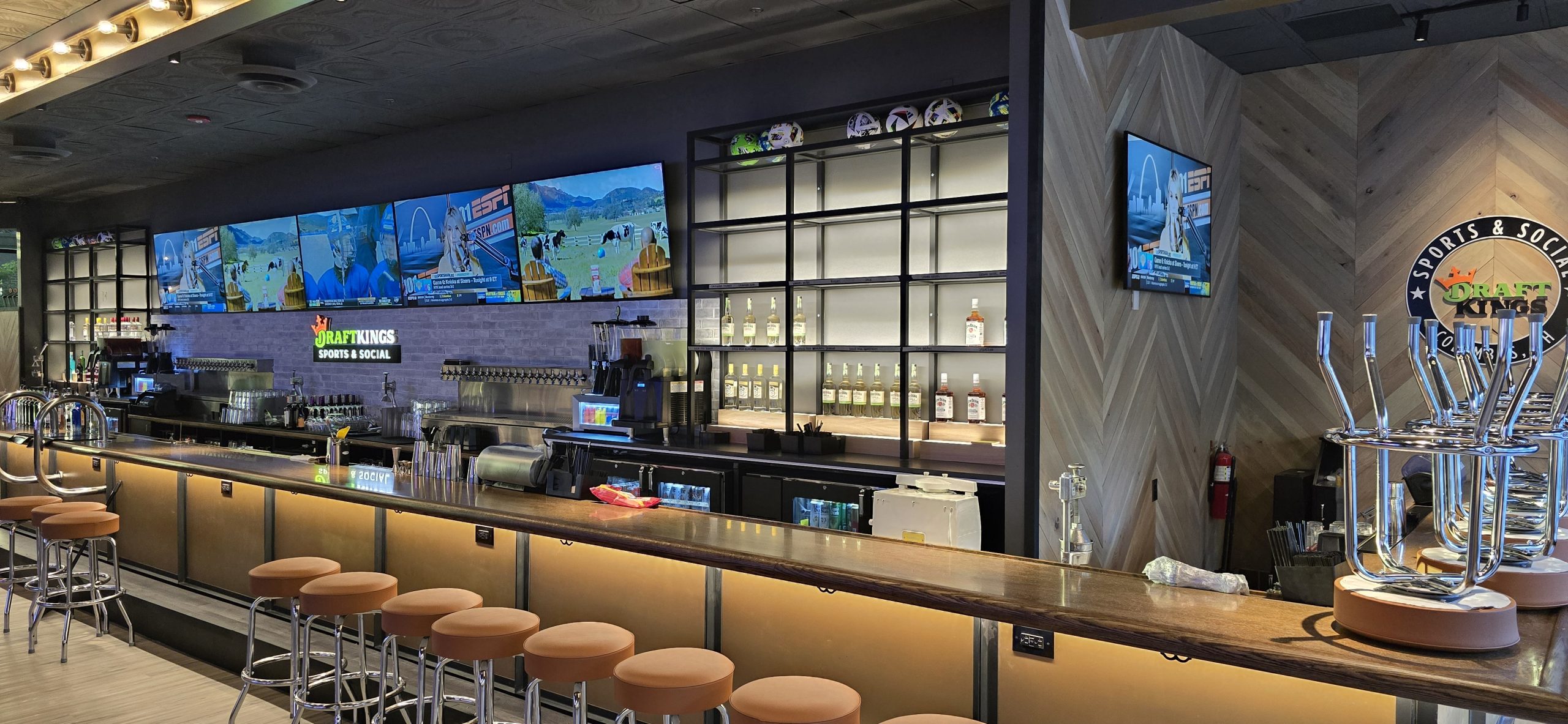 Main bar in front of dining area with TV video wall