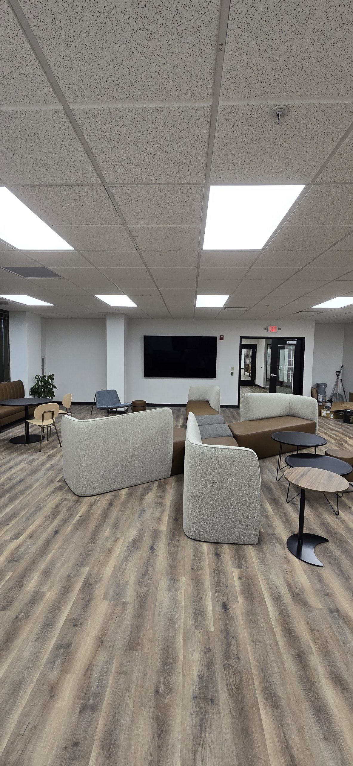 employee breakroom with sofas and chairs and big screen display tv