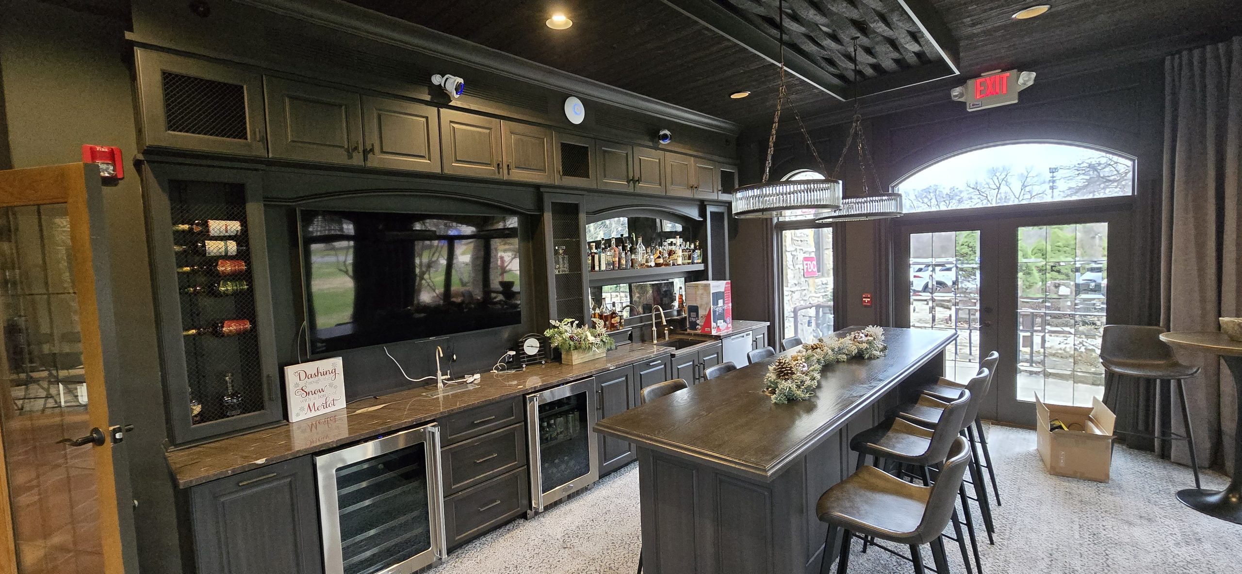 elegant lounge area with wooden bar and hanging chandeliers